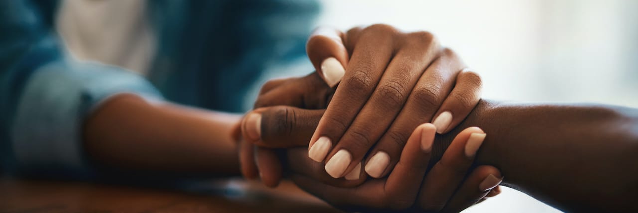 Closeup shot of two Black women holding hands