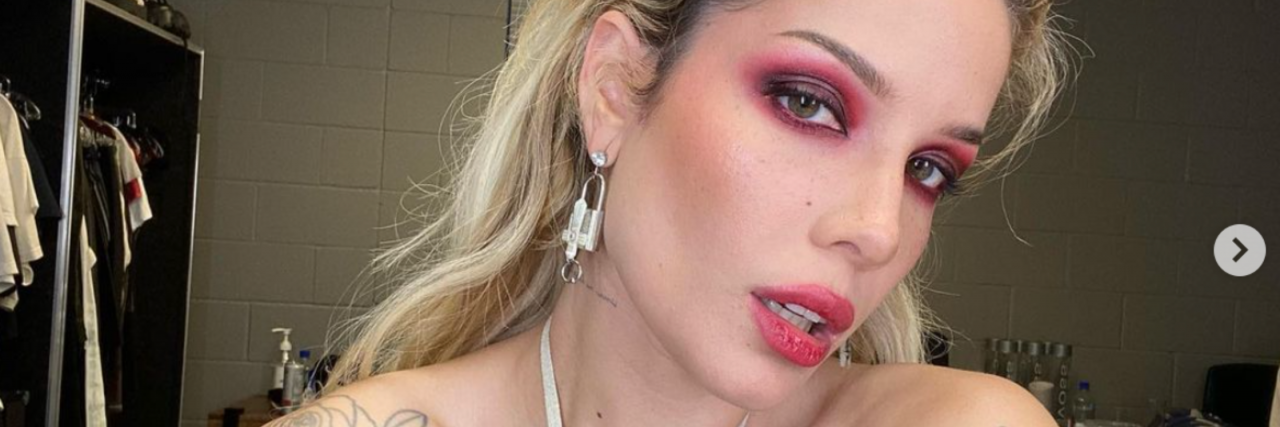 Why Halsey Talking About Her Post-Miscarriage Abortion Was Lifesaving Halsey looking into the camera sporting bright eyeshadow and a lipstick in a white top with their hair up.