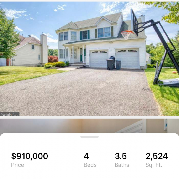 Screenshot from redfin of a white house with a big driveway and a basketball hoop