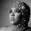 Lizzo looking off into the distance with a sparkly shimmery headpiece