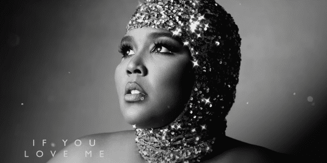 Lizzo looking off into the distance with a sparkly shimmery headpiece