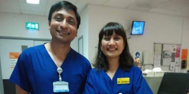 A Day in My Life as a Doctor for 'Miracle Babies' in the Neonatal Hospital Unit  The author, a man with black hair and eyes wearing blue scrubs stands in the hospital alongside a woman in blue scrubs.
