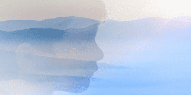 A double exposure of a boy with eyes closed over a dreamy landscape