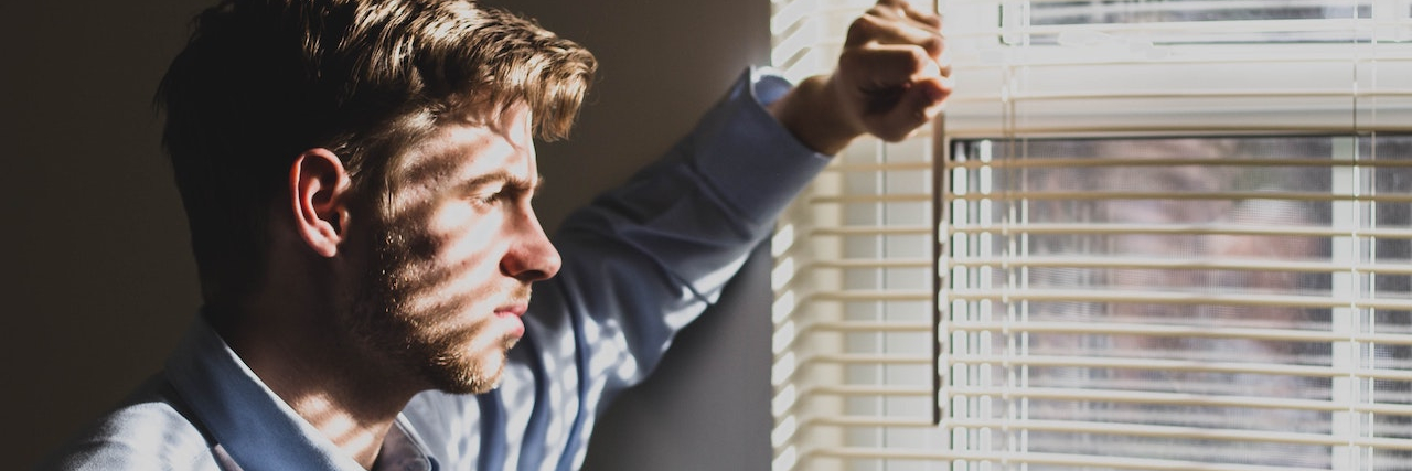 Ways My Mother Used Financial Abuse to Control and Ridicule Me Man looking out a window