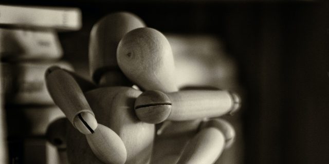 Two wooden figures embracing.