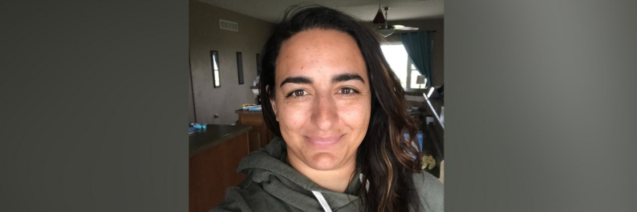 The Importance of Trigger Warnings for Those Living With PTSD Image of contributor wearing a hoodie and slightly smiling at camera