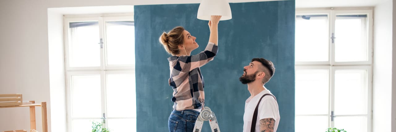 photo of a young couple changing a light bulb