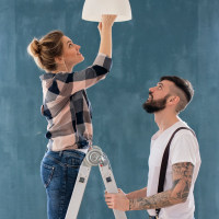 photo of a young couple changing a light bulb