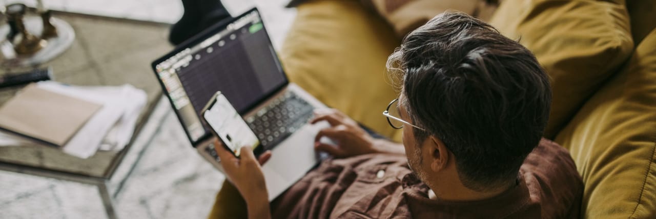 Protecting Working From Home for People With Chronic Illness and Disabilities Man working from home sitting on sofa.