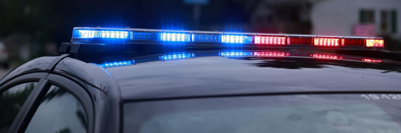 The Dangerous Reality of Police Response to Mental Health Crises Police car lights outside a house