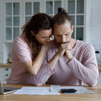 photo of a young couple looking stressed about finances