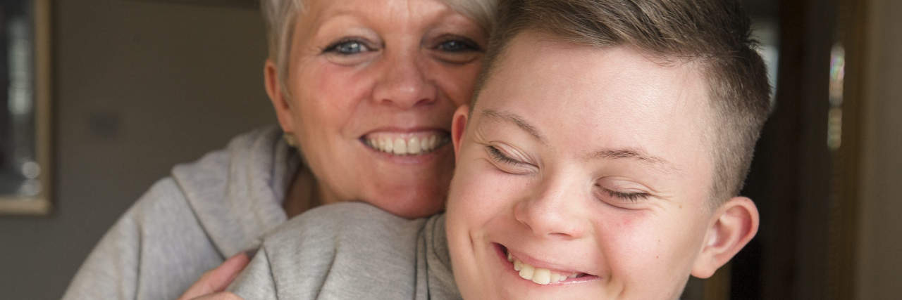 Teen boy with Down syndrome and his mother.