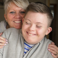 Teen boy with Down syndrome and his mother.