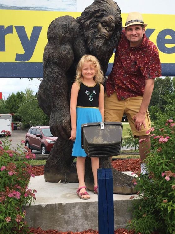 Ron and his daughter with a Bigfoot statue.