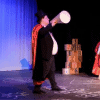Shot from the production "Matilda the Musical" featuring an older man yelling and young woman in red to the side