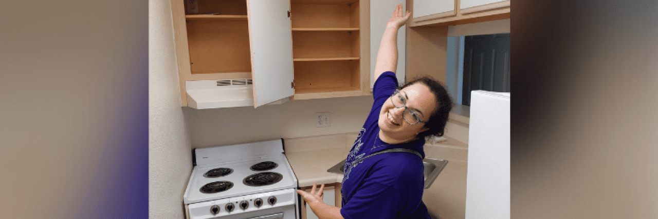 Contributor standing in front of empty shelves in kitchen of old apartment