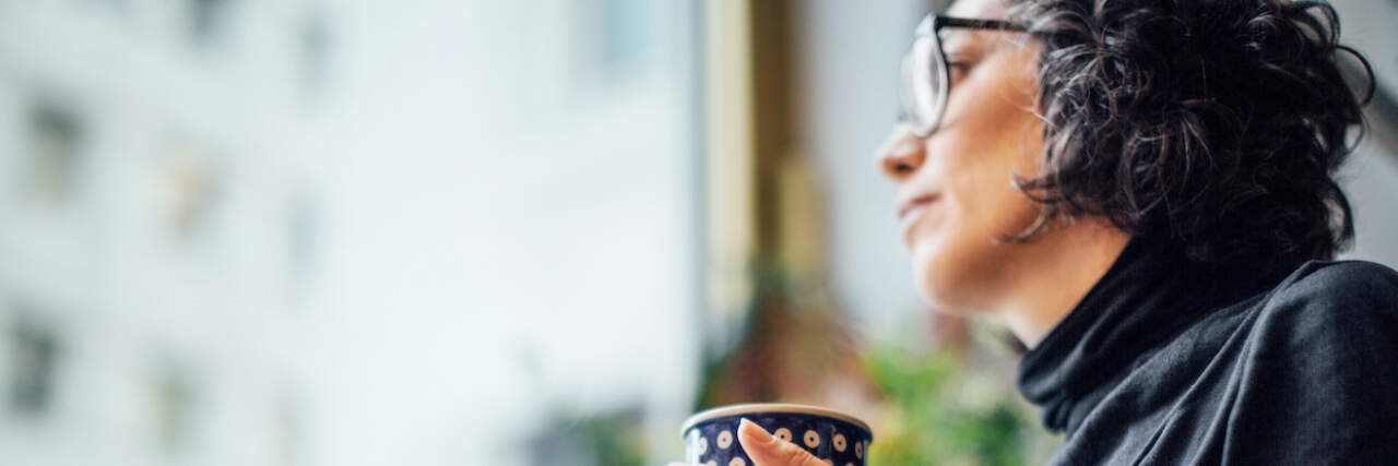 When You Have OCD and Are Going Through Menopause Low angle shot of woman looking out of window with a coffee cup.