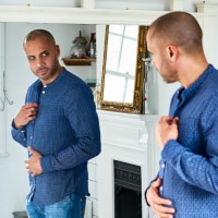 photo of a man looking into the mirror with concerned expression