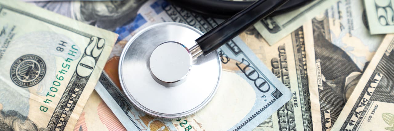 Stethoscope on top of a pile of money.