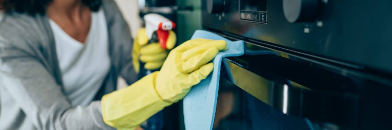 7 Ways People With ADHD 'Lie' to Themselves Woman wiping surface at home.