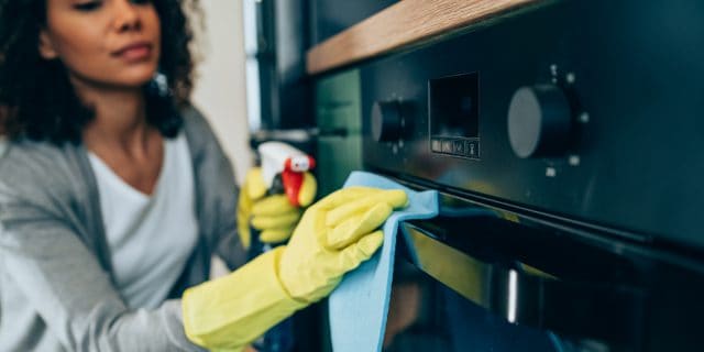 Woman wiping surface at home.