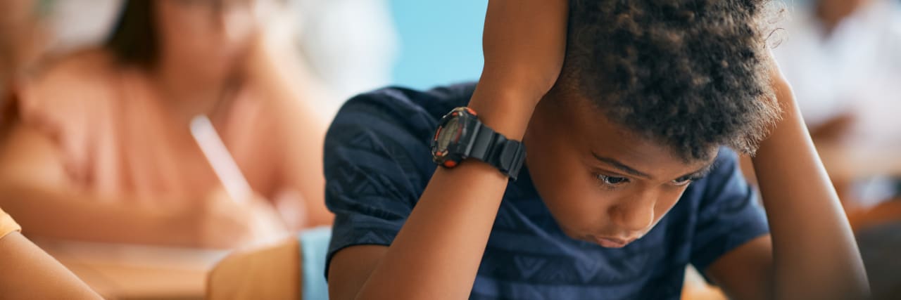 Mental Health Stories You Need to Read In Time for Going Back to School or College A boy in school taking an exam, stressed