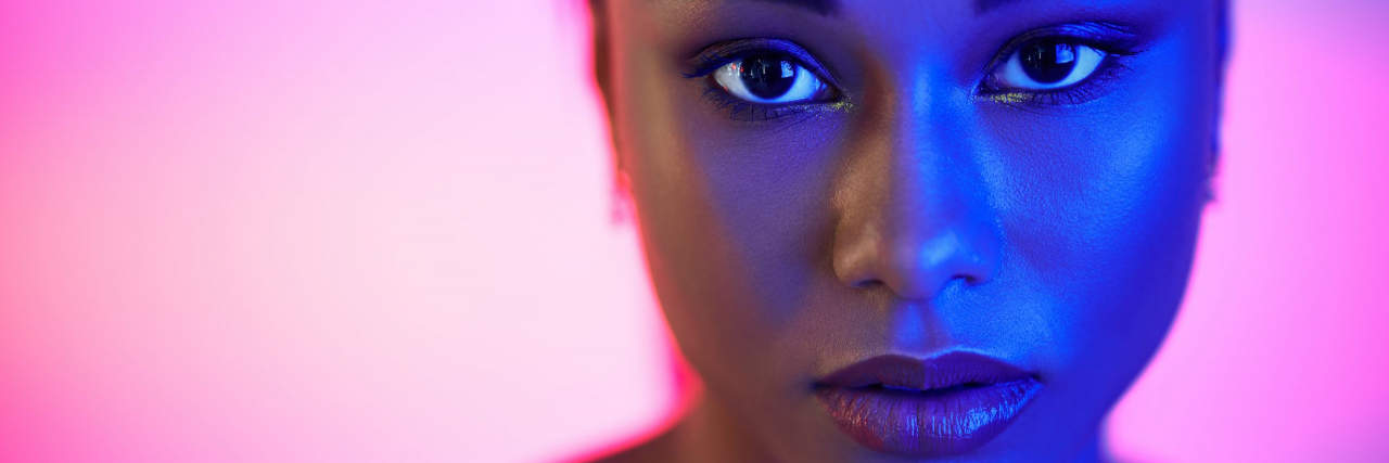 Closeup portrait of pretty african american woman in bright neon lights