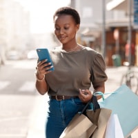 Shot of an attractive young woman using her cellphone outside while shopping in the city
