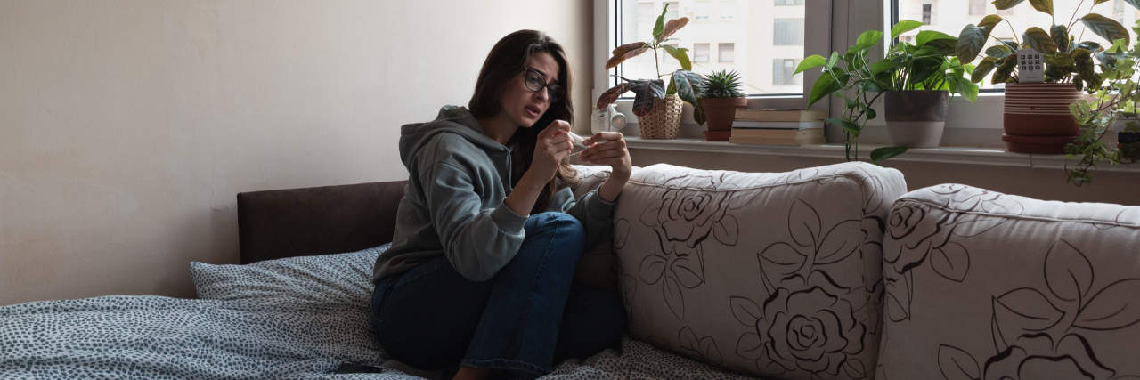 Navigating a Pelvic Mass and Chronic Health Issues in a Post-Roe USA Woman looking at pregnancy test