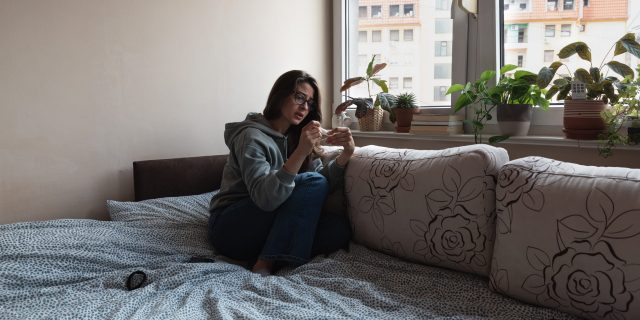 Navigating a Pelvic Mass and Chronic Health Issues in a Post-Roe USA Woman looking at pregnancy test