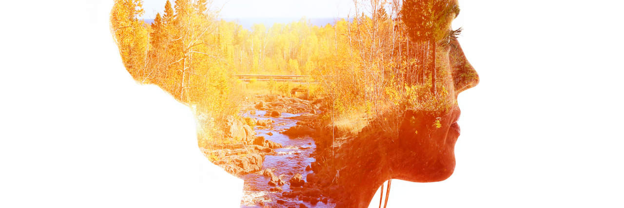 double exposure of a woman and a forest with a river at sunset
