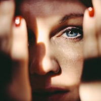 Woman emerging from behind her hands