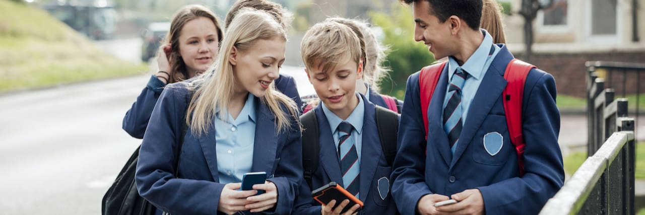 A Parents' Guide to Protecting Children From Sexual Abuse at School Group of teenage students walking home from school together on their phones