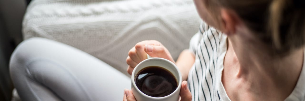 Reframing Suicidal Thoughts to Consider the Many Little Things I Keep Living For Overhead view of woman sitting on couch with coffee mug