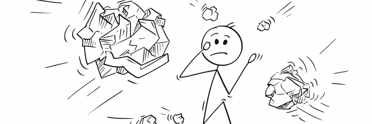 Drawing of a man with crumpled paper balls flying at him.