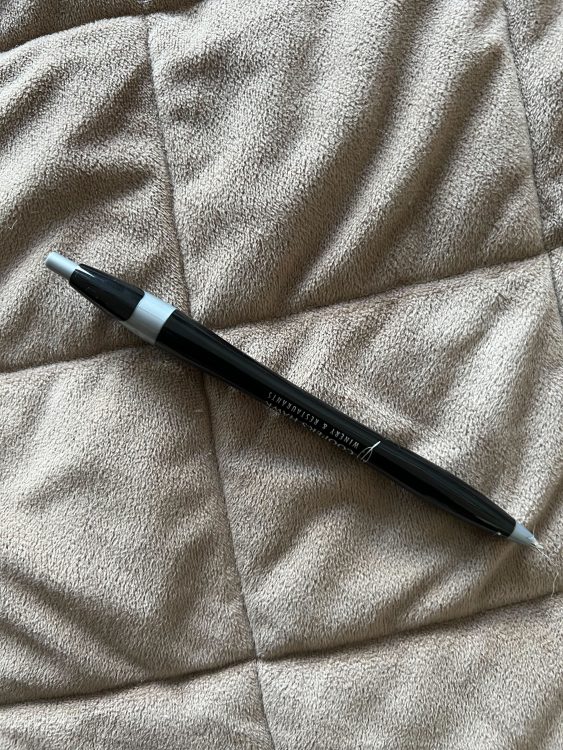 A black pen against a brown backdrop