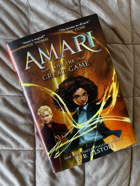 The book "Amari and the Great Game" against a brown backdrop.