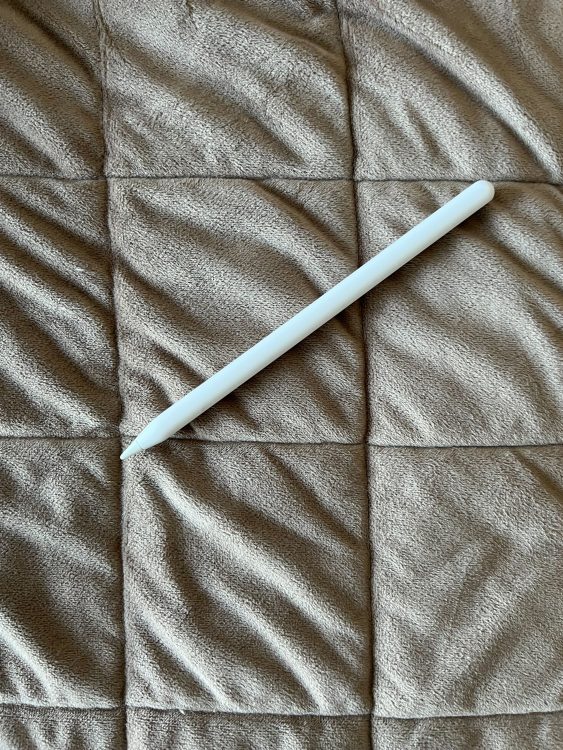 An apple pencil against a brown backdrop