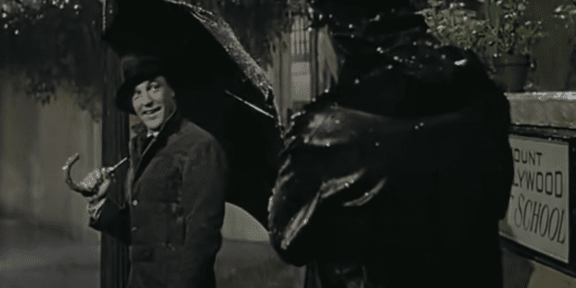 Gene Kelly in "Singing in the Rain" staring at a cop in the rain during the "Singing in the Rain" musical sequence in the movie.