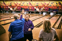 picture of aaron and family bowling together.