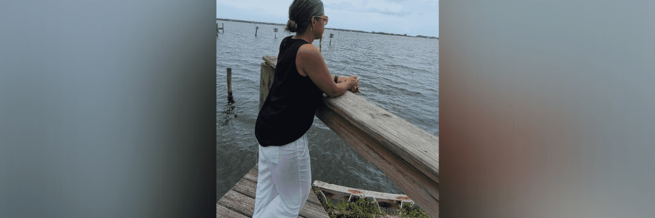 Photo of contributor looking out over the ocean standing on a dock