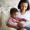 Woman of color reading a book with her son