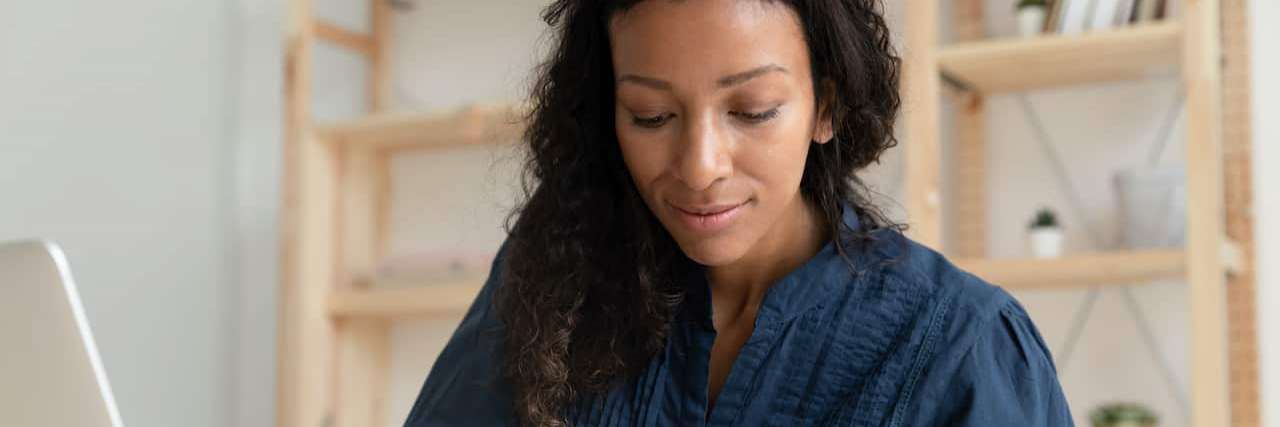 Advocating for People With Myasthenia Gravis Became My Life’s Purpose Black woman concentrating and writing notes