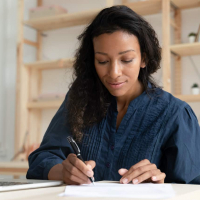 Black woman concentrating and writing notes