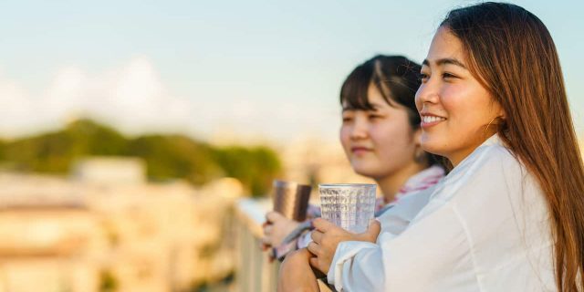 What Accepting Bipolar Disorder Means to My Sibling Relationship Two Asian women standing outside and smiling