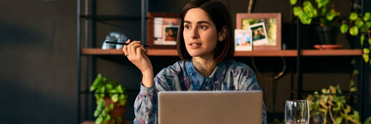Coping With Rejection in the Workplace When You Have Bipolar Disorder Woman holding a pen and sitting in front of a laptop