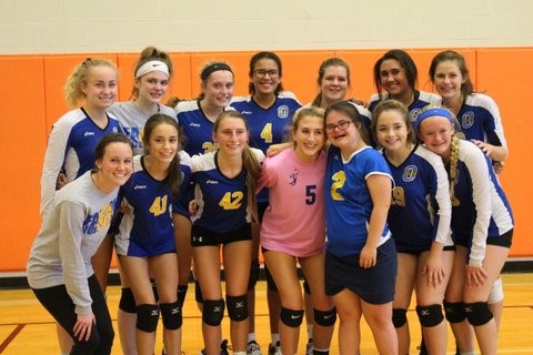 Rachel posing happily with volleyball team
