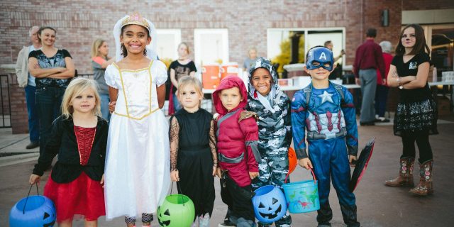 Diverse group of kids wearing Halloween costumes