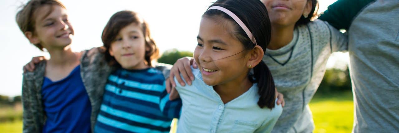 How Social-Emotional Learning (SEL) Can Improve Youth Mental Health A group of multi-ethnic youth stand together outside on a warm fall day with arms around each other