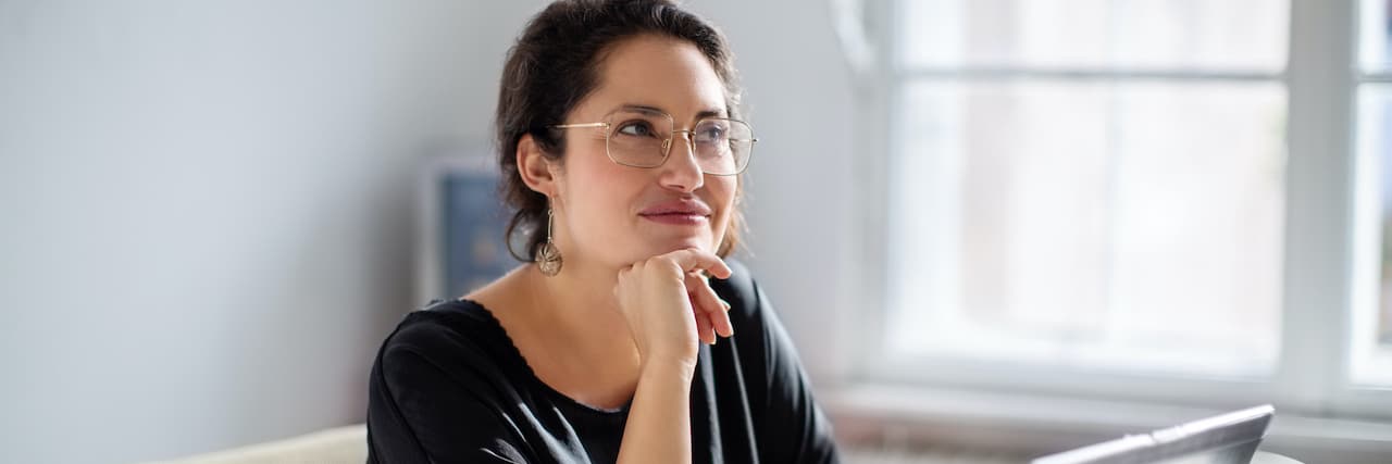 Superpowers and Opportunities That Can Come With Having a Disability Woman sitting next to laptop and looking away as if in thought
